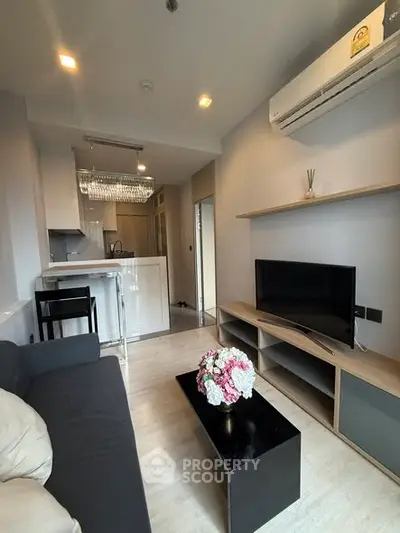 Modern living room with sleek furniture and open kitchen layout in a stylish apartment.