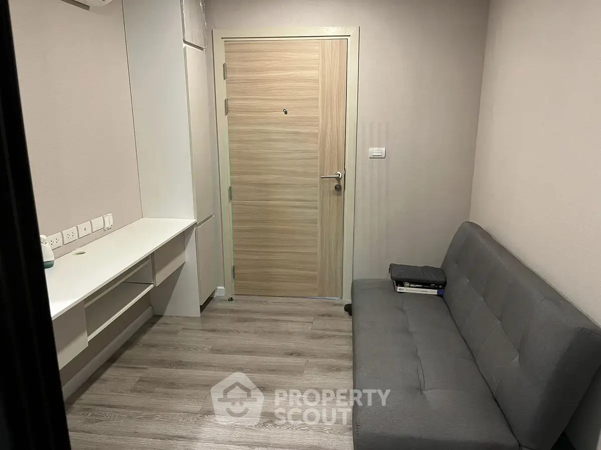 Cozy study room with modern sofa and built-in desk, perfect for productivity.
