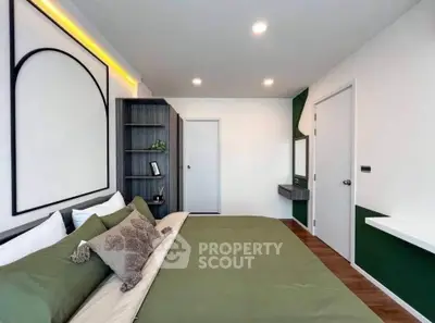 Modern bedroom with stylish decor and green accents, featuring a cozy bed and built-in storage.
