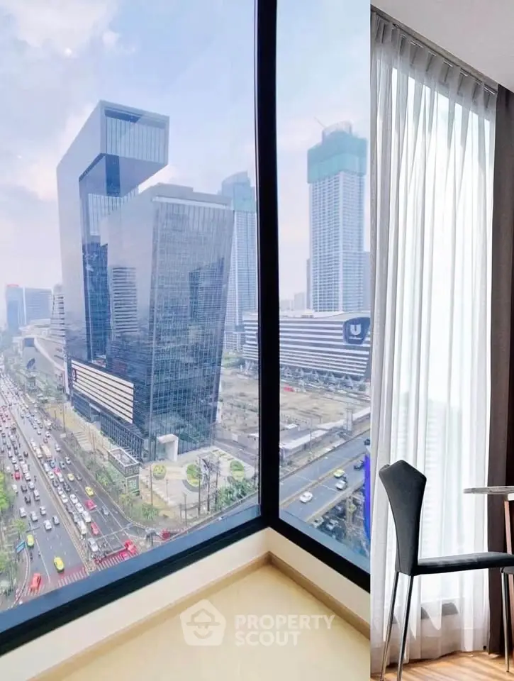 Stunning city view from modern high-rise apartment corner unit with floor-to-ceiling windows.