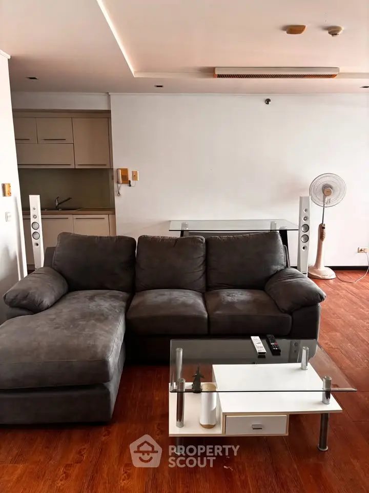 Modern living room with plush gray sofa, sleek coffee table, and stylish wooden flooring.