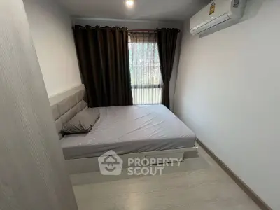 Cozy bedroom with modern decor and natural light, featuring a comfortable bed and air conditioning.