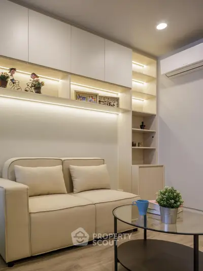 Modern living room with cozy beige sofa, glass coffee table, and stylish built-in shelves.