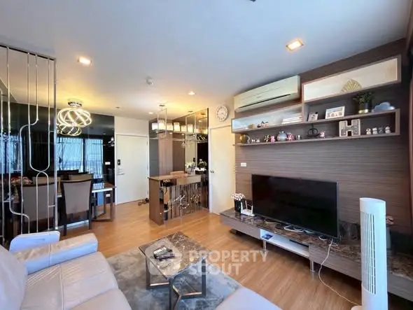 Modern living room with stylish decor and open layout, featuring a cozy seating area and sleek entertainment center.