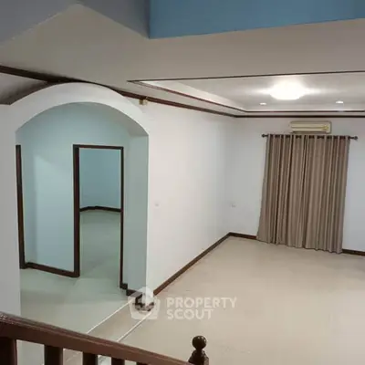 Spacious living room with elegant archway and neutral decor
