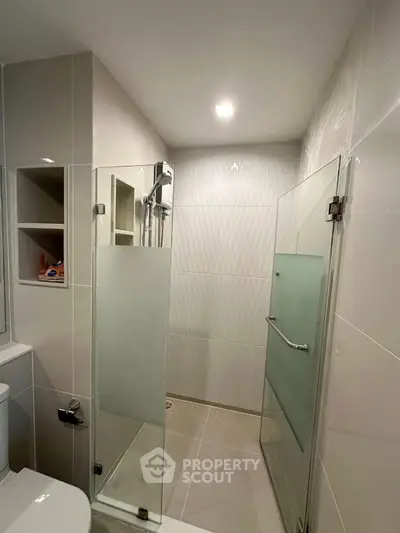 Modern bathroom with glass shower enclosure and sleek tile design