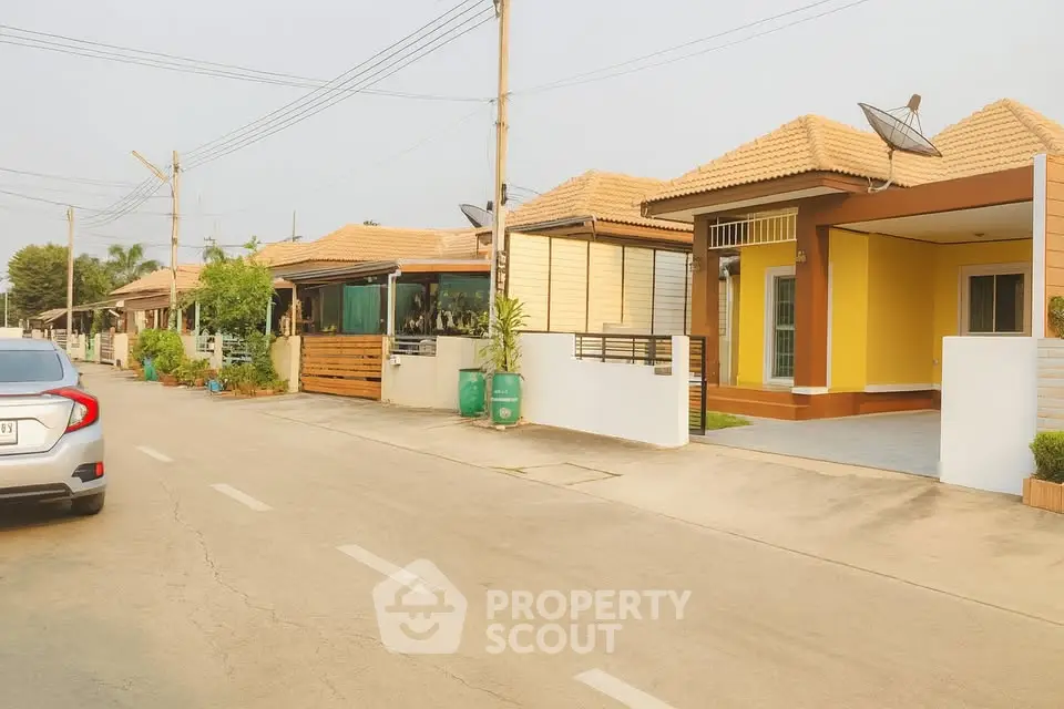 Charming suburban street with modern single-story homes and well-maintained gardens.