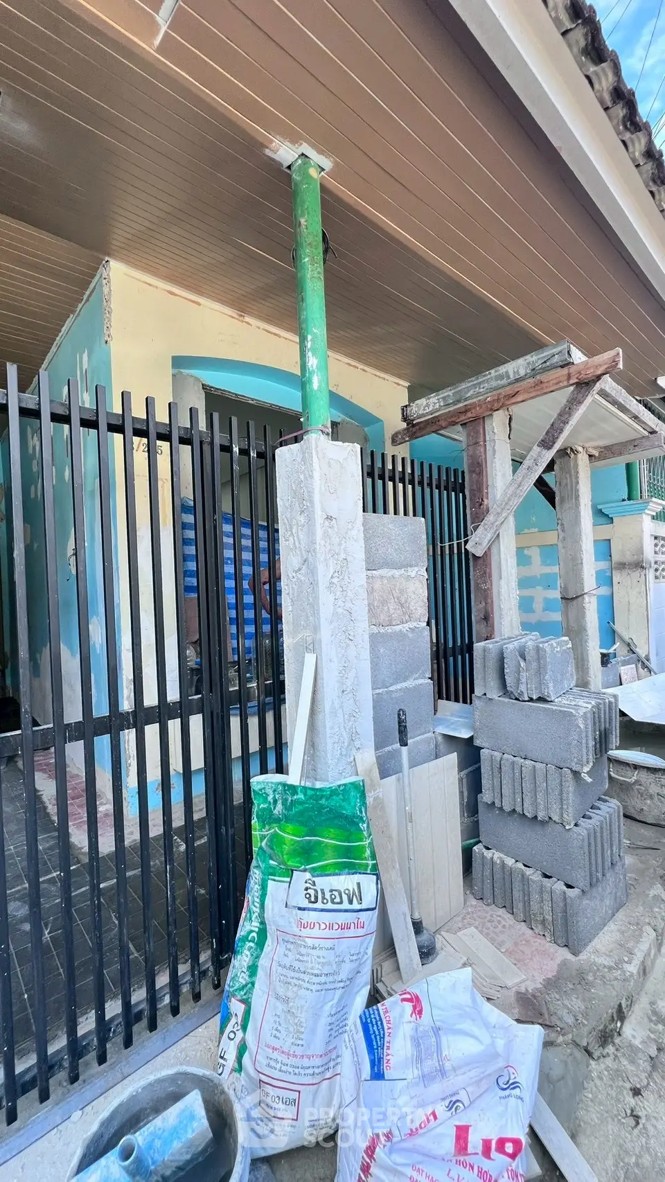 Under-construction exterior with building materials and fence