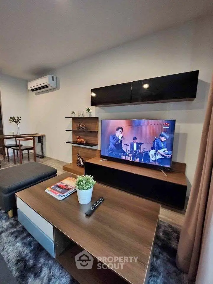 Modern living room with stylish furniture and entertainment setup, featuring a sleek TV and cozy decor.