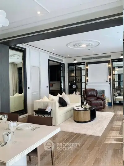 Luxurious living room with elegant decor and open layout, featuring plush seating and stylish dining area.