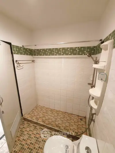 Spacious bathroom with modern shower and tiled design, perfect for relaxation.