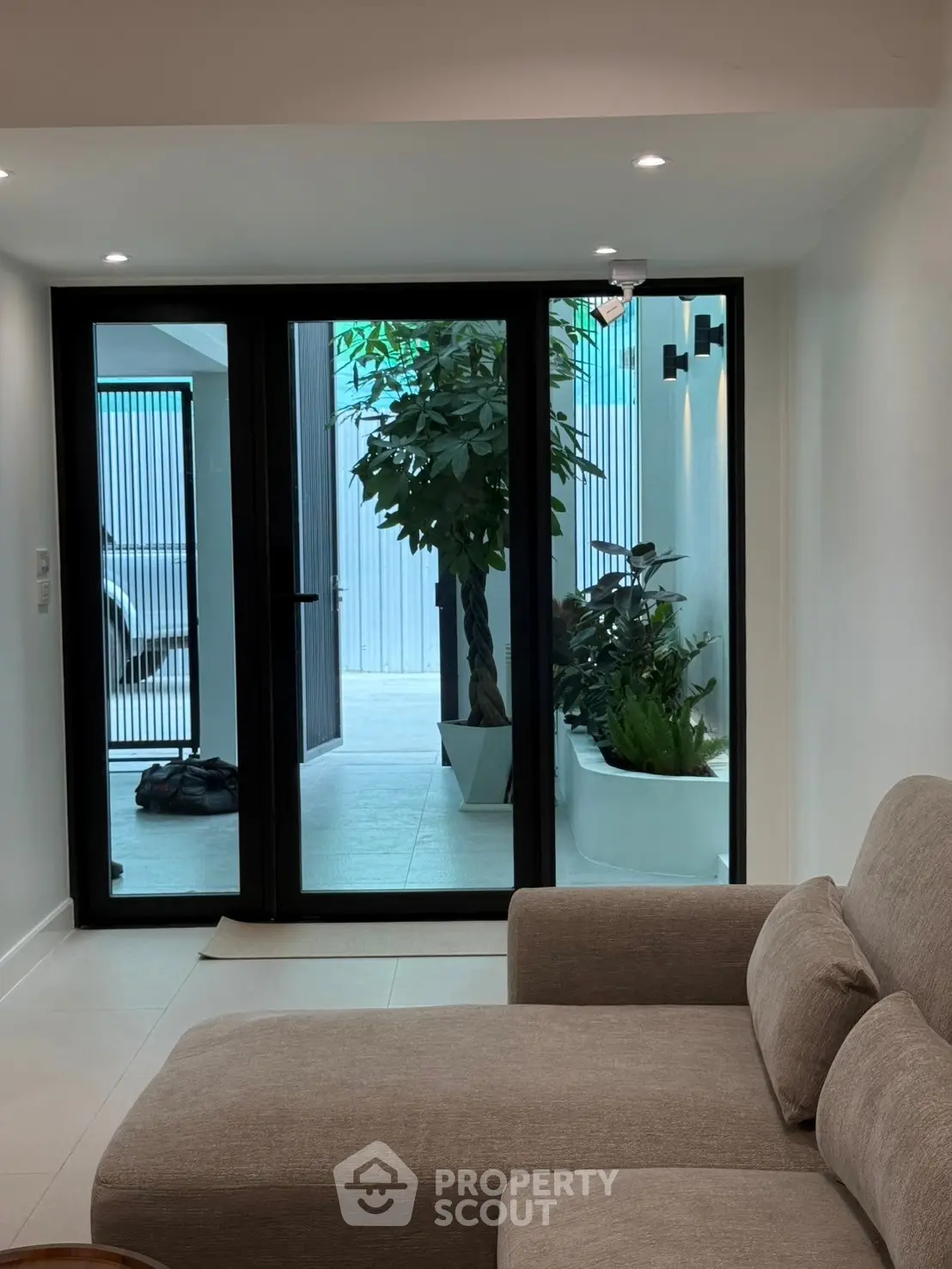 Modern living room with large glass doors leading to a stylish outdoor area.