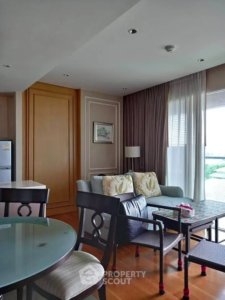 Charming living room with elegant decor and natural light, featuring a cozy sofa and dining area.