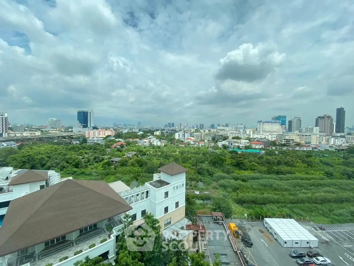 Stunning cityscape view from high-rise building with lush greenery and skyline.