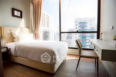 Bright bedroom with large window and modern decor in urban apartment