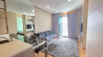 Modern living room with open kitchen and balcony view in a stylish apartment.