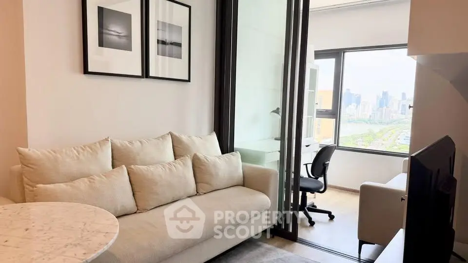 Modern living room with city view, featuring cozy sofa and stylish decor in a high-rise apartment.