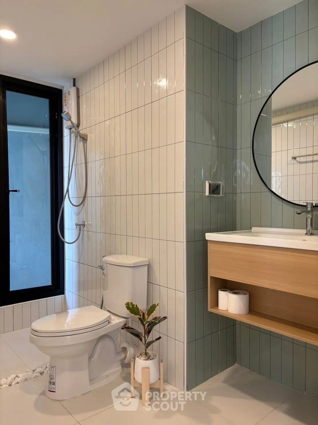 Modern bathroom with sleek design, featuring a round mirror, shower, and stylish tiles.