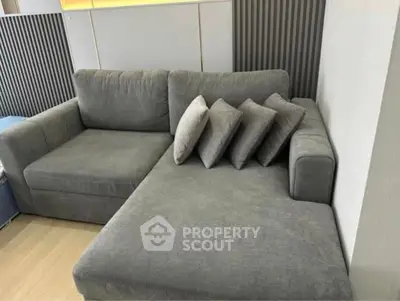 Modern living room with stylish gray sectional sofa and decorative pillows.