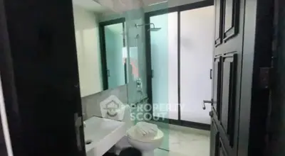 Modern bathroom with glass shower and sleek fixtures in a contemporary home.