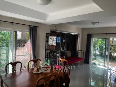 Spacious living room with elegant dining area and garden view, perfect for family gatherings.