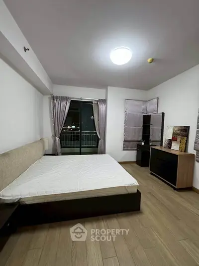 Spacious bedroom with modern furnishings and balcony access in a stylish apartment.