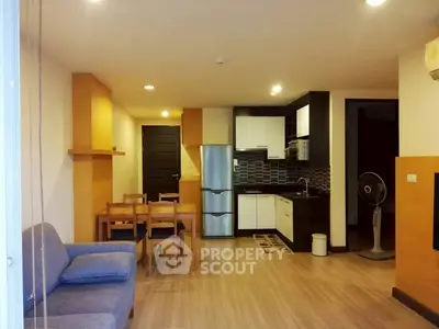 Modern open-plan living room with kitchen featuring sleek appliances and stylish decor.