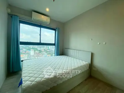 Modern bedroom with city view and air conditioning in high-rise apartment.