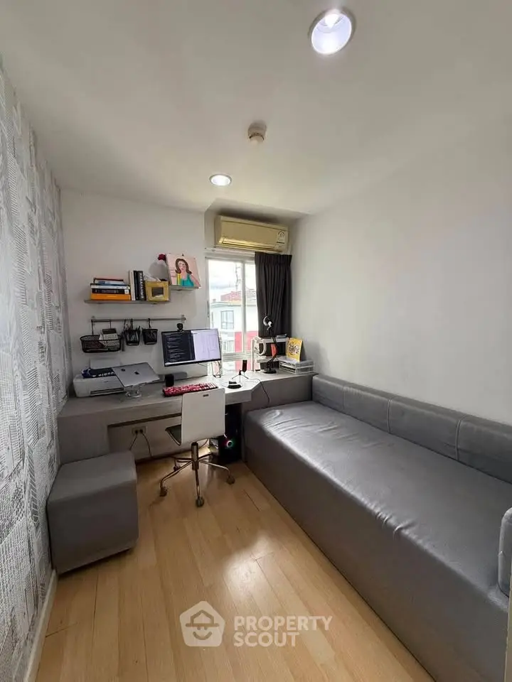 Modern study room with sleek desk, computer setup, and comfortable seating in a bright, compact space.