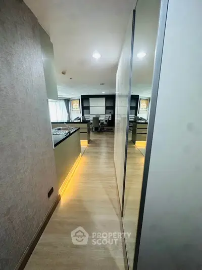 Modern hallway with sleek design and ambient lighting leading to a stylish living area.