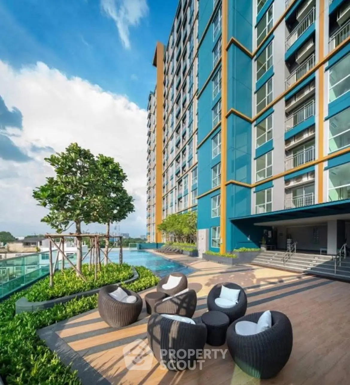 Modern high-rise building with stylish outdoor seating and lush greenery.
