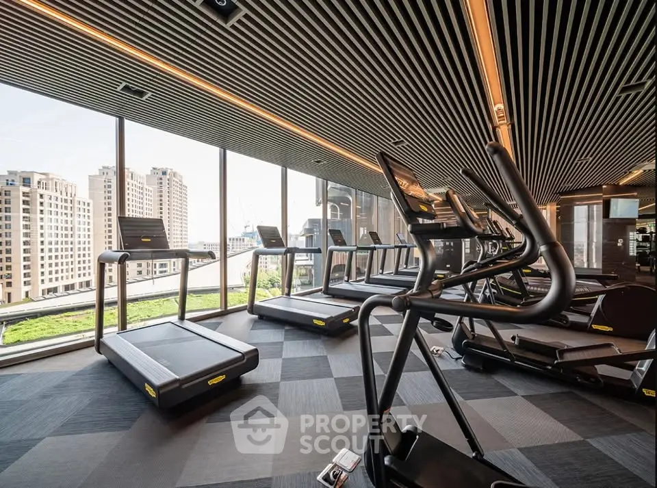 Modern gym with city view and state-of-the-art equipment in luxury building.