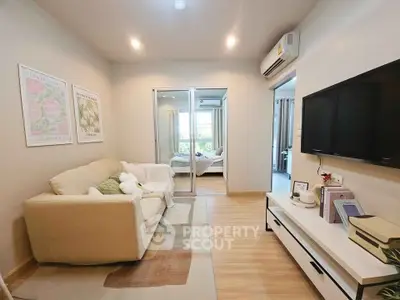 Cozy living room with modern decor and sliding glass doors leading to a bedroom, perfect for urban living.