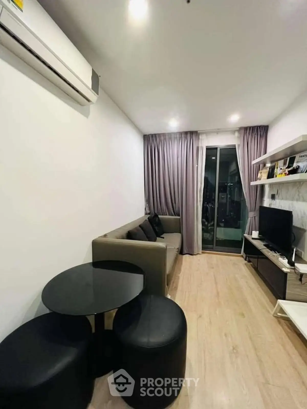 Modern living room with sleek furniture and balcony access in a stylish apartment.