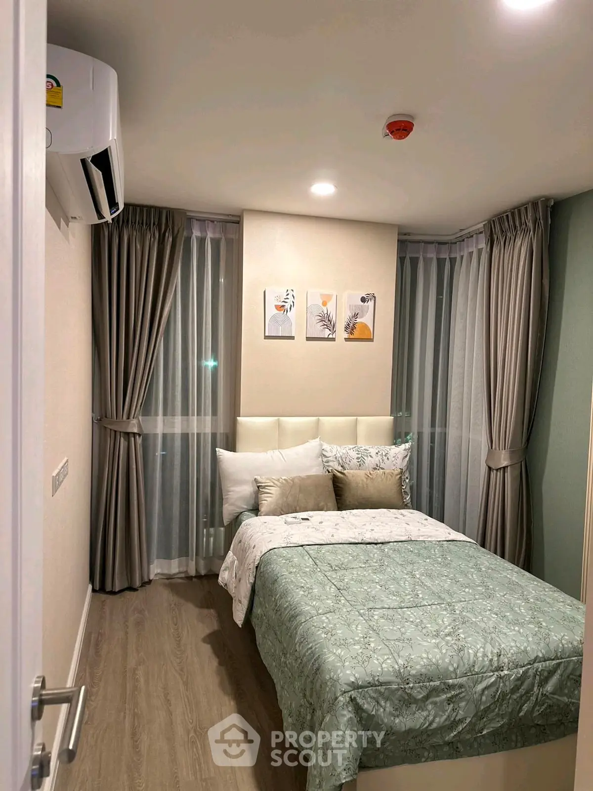 Cozy bedroom with modern decor and large windows in a stylish apartment.