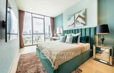 Luxurious bedroom with city view, elegant decor, and modern furnishings in high-rise apartment.