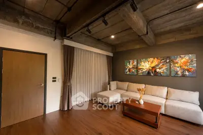 Stylish living room with modern decor and cozy seating in an industrial-style apartment.