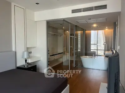 Luxurious bedroom with glass-enclosed bathroom and city view, featuring modern design and elegant finishes.