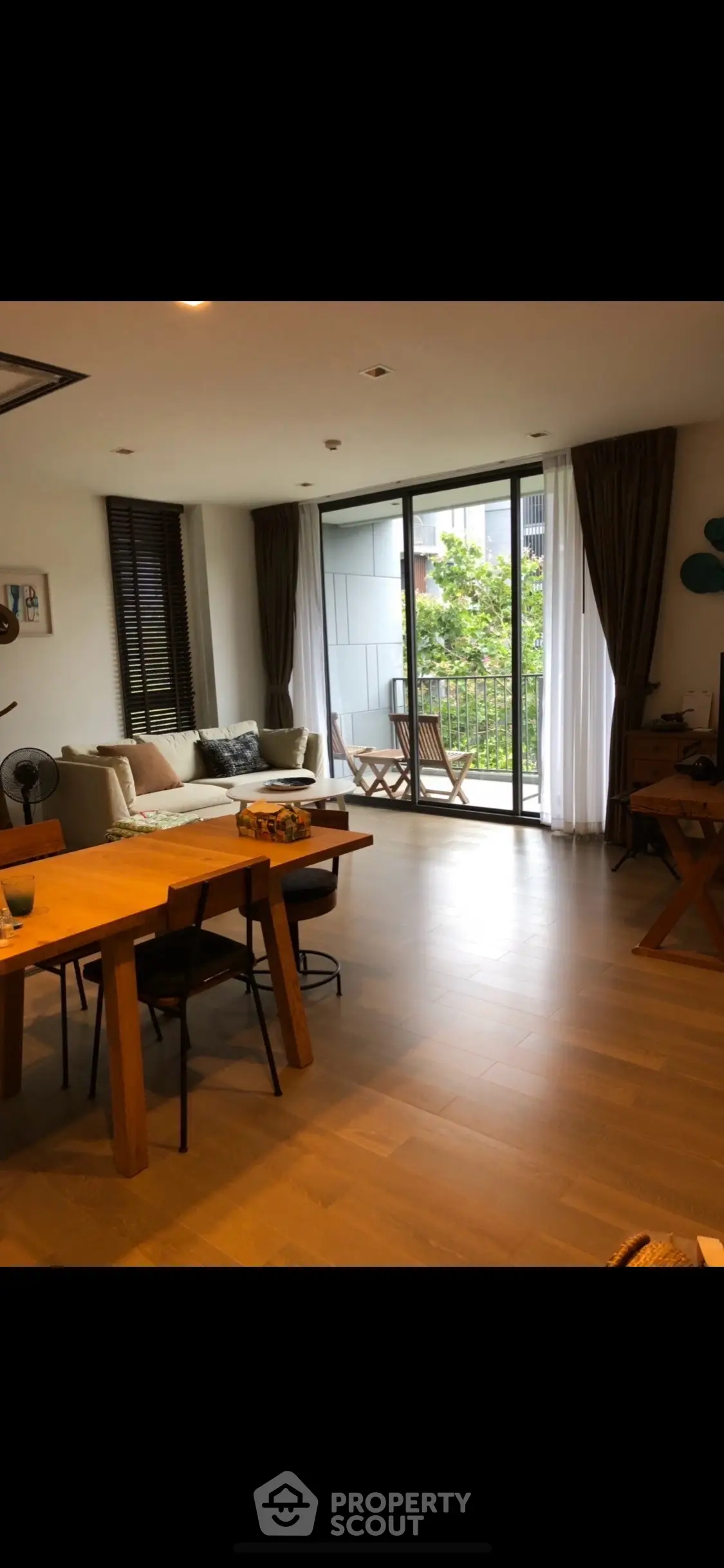 Spacious living room with large windows and balcony access in modern apartment.