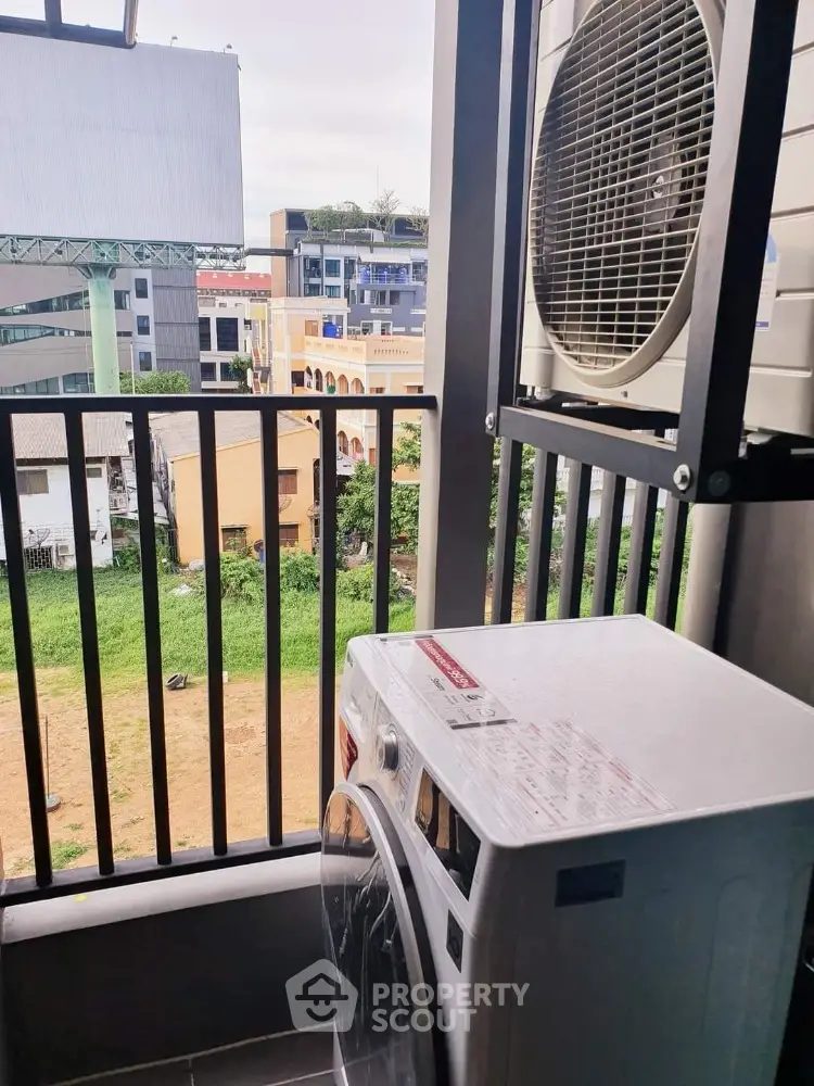 Modern balcony with washing machine and city view, perfect for urban living convenience.