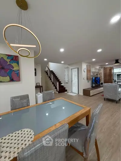 Modern living room with stylish dining area and staircase in contemporary home