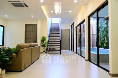 Spacious modern living room with elegant staircase and natural light