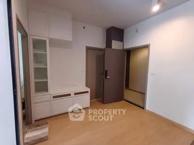 Spacious modern living room with wooden flooring and built-in storage cabinets.