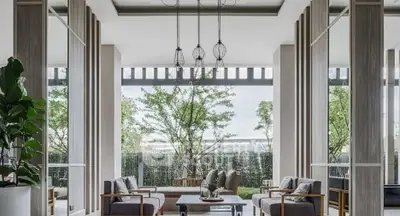 Luxurious modern living room with elegant decor and large windows overlooking greenery.