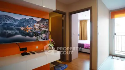 Modern apartment interior with vibrant orange accents and wall-mounted TV, showcasing a cozy bedroom and balcony.