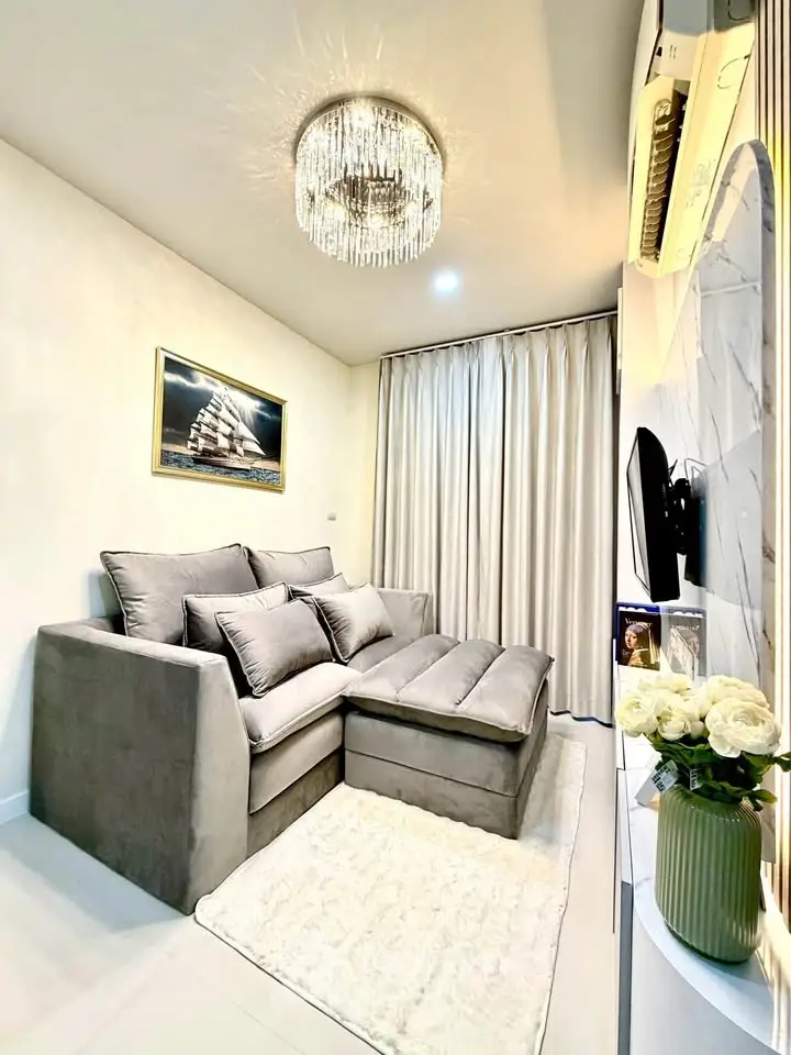 Cozy living room with plush gray sofa, elegant chandelier, and modern decor