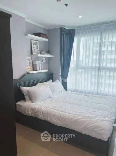 Cozy bedroom with large window and modern decor in a stylish apartment.