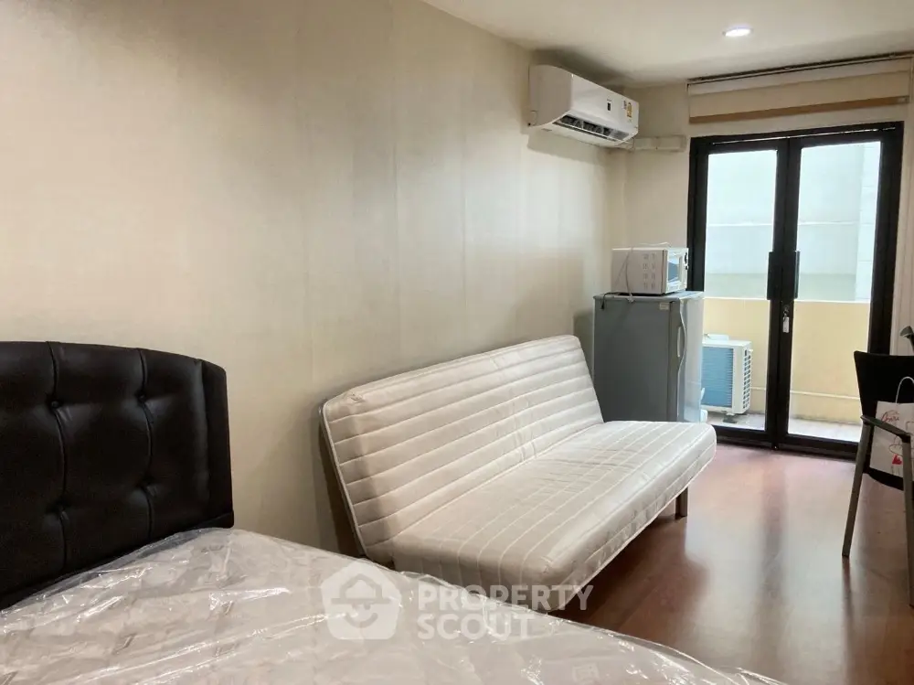 Cozy studio apartment with modern furnishings and balcony access