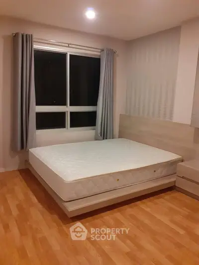 Spacious bedroom with modern design and large window for natural light.
