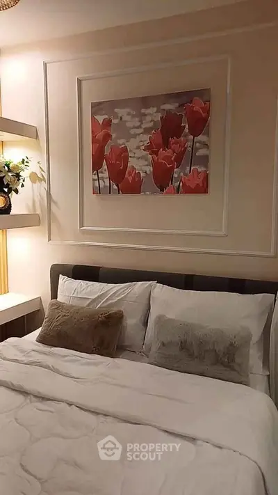 Cozy bedroom with elegant decor and floral artwork, perfect for relaxation and comfort.